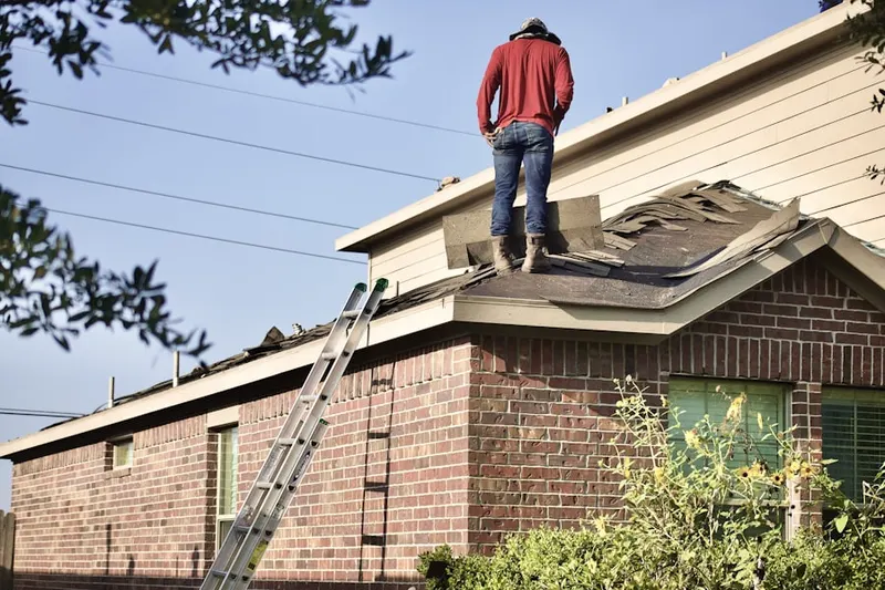 Professional roofer working on a residential roof in Roberts